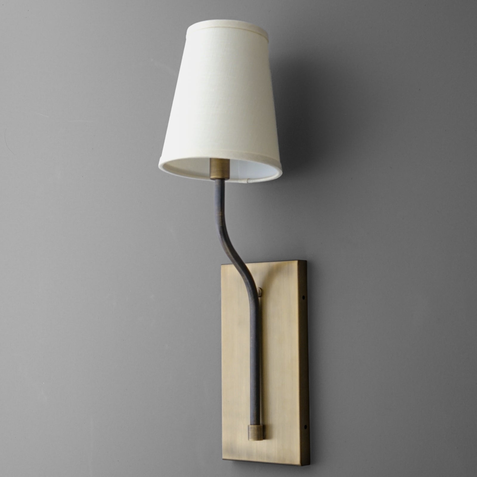 Wall-mounted brass sconce with a curved arm and white tapered fabric shade. - SCONCE MODEL NO. 9714