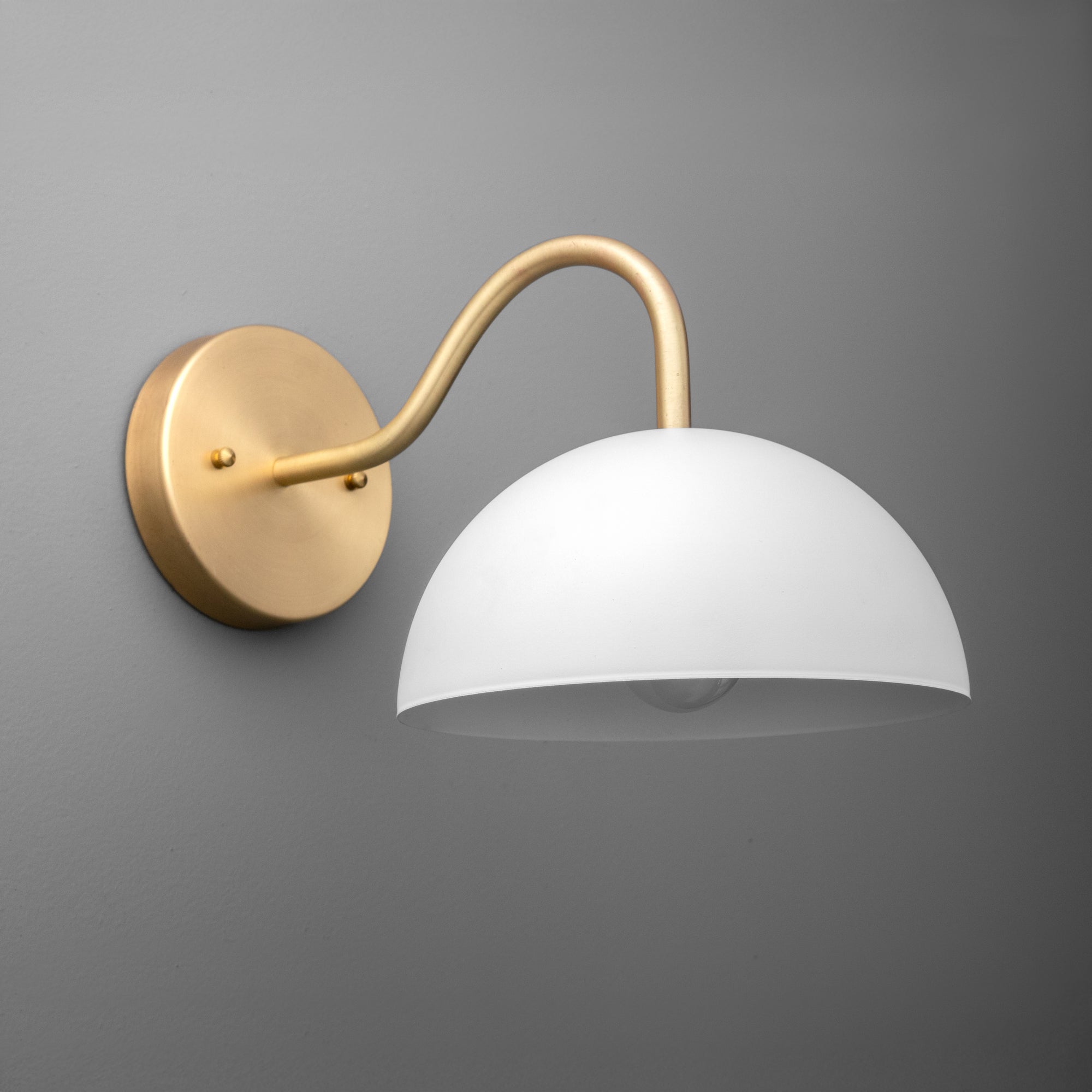 Wall-mounted dome sconce with matte white shade and curved raw brass arm and base. - SCONCE MODEL NO. 6679
