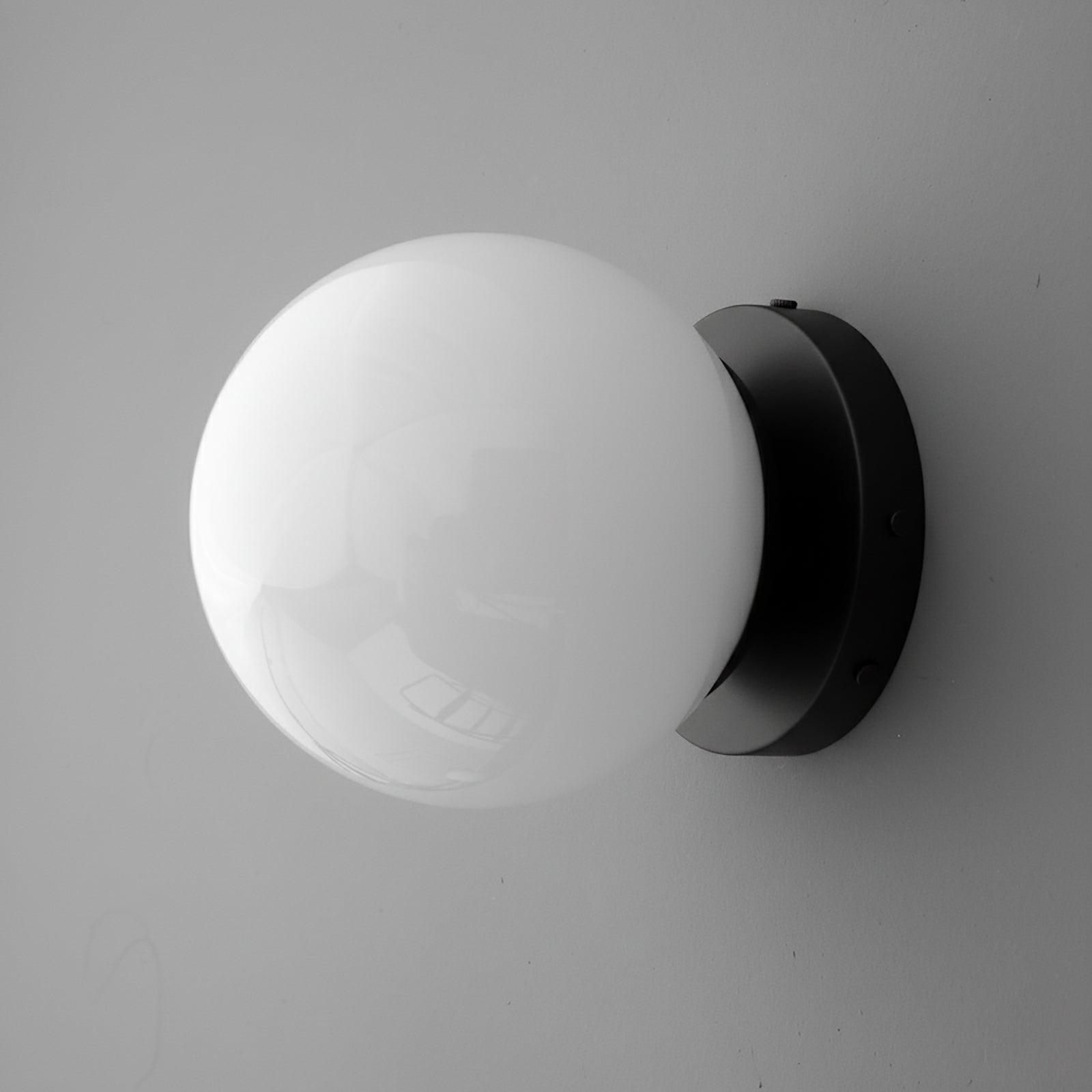 Round white glass globe sconce with black metal base wall mount, single bulb design. - SCONCE MODEL NO. 3825