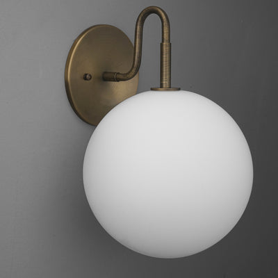 Wall-mounted sconce with matte white glass globe and antique brass curved arm and base. - SCONCE MODEL NO. 0478