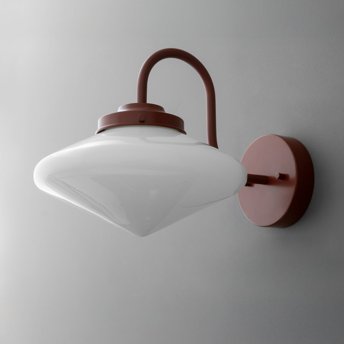 White frosted glass single-bulb sconce with curved rust-colored metal arm and round wall mount. - SCONCE MODEL NO. 1019
