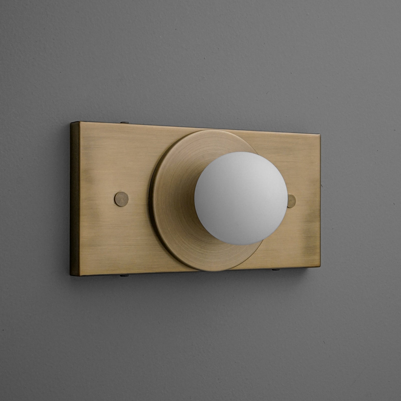Antique brass wall sconce with round white globe light on rectangular backplate. - SCONCE MODEL NO. 4474