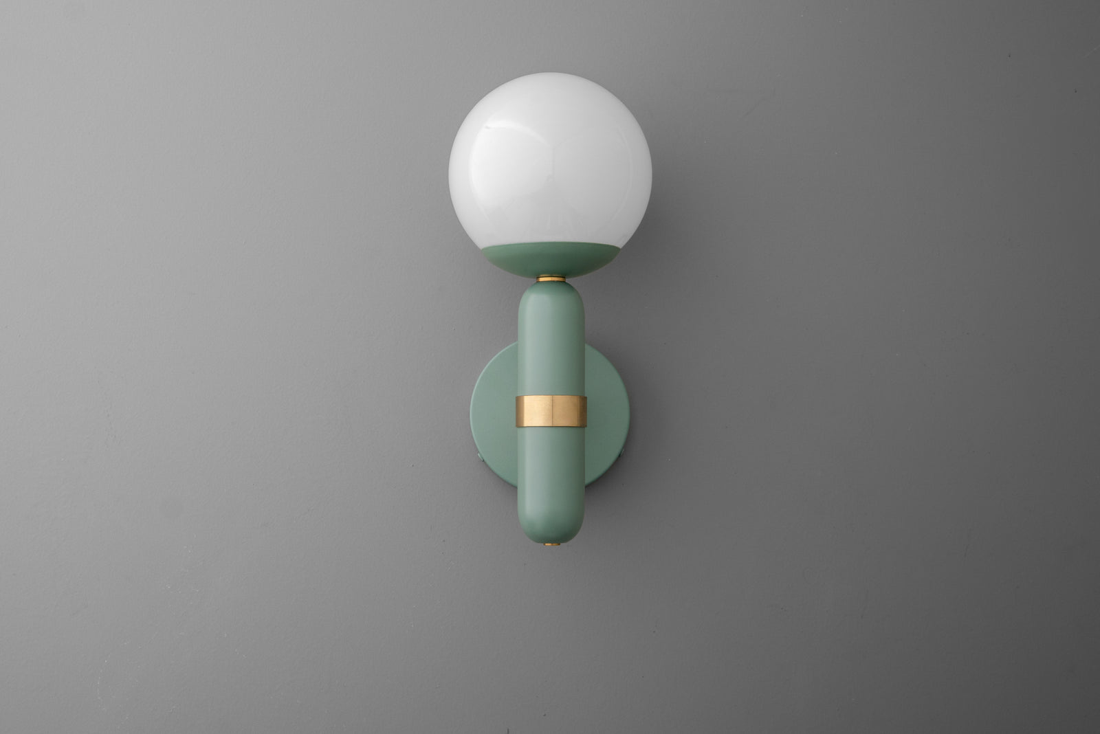 Wall-mounted sconce with round white glass shade and matte green brass fixture with gold accent. - SCONCE MODEL NO. 4786