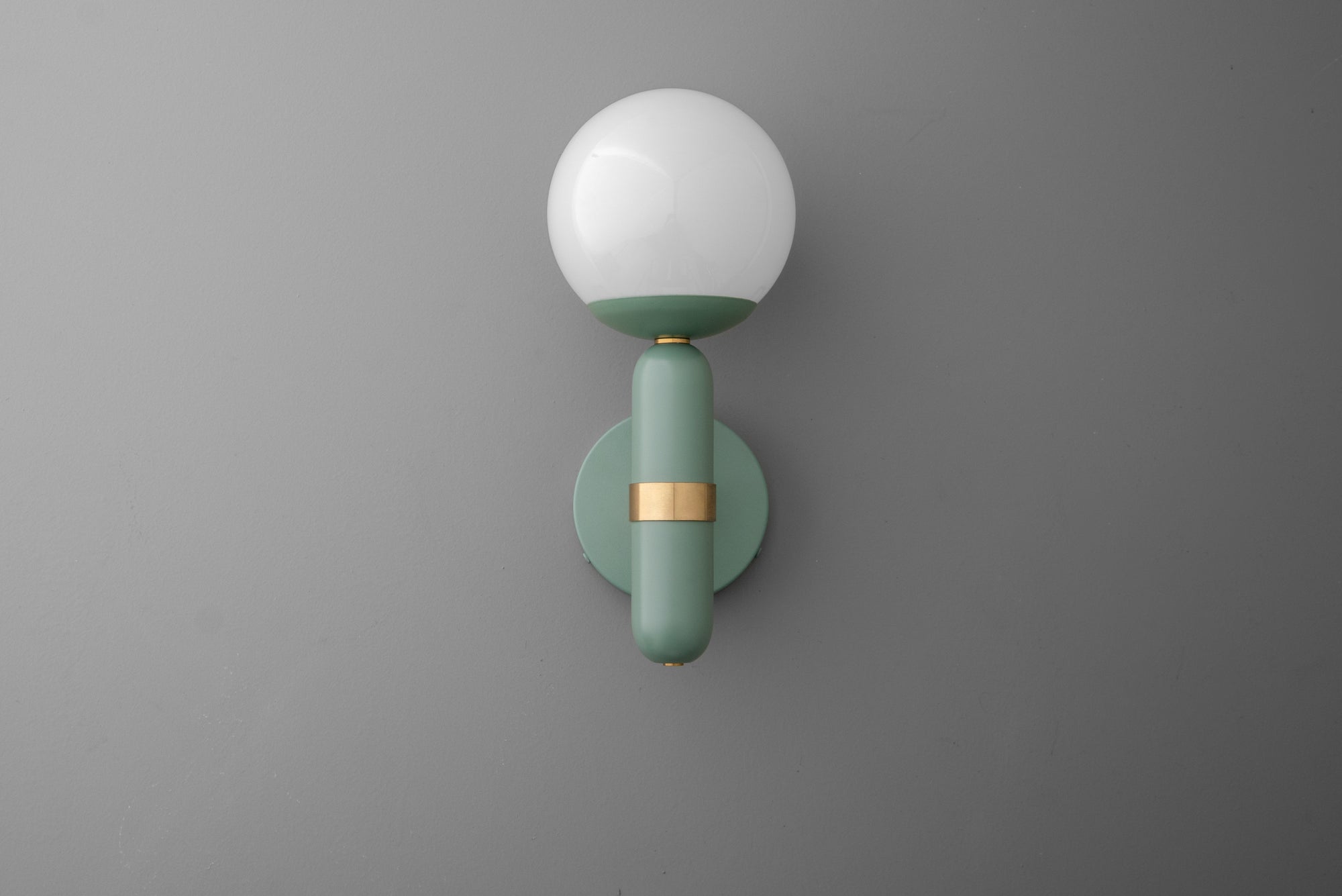 Wall-mounted sconce with round white glass shade and matte green brass fixture with gold accent. - SCONCE MODEL NO. 4786