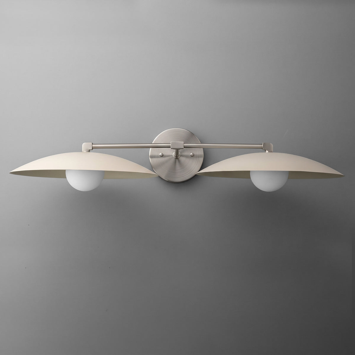 Matte nickel dual-arm vanity light with two round white glass bulbs and flat dome shades. - VANITY LIGHT MODEL NO. 1168