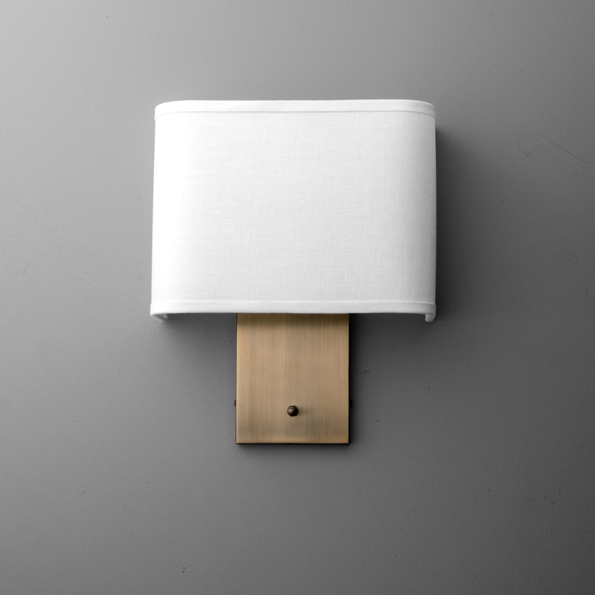 Wall sconce with rectangular white fabric shade and brushed brass rectangular backplate. - SCONCE MODEL NO. 1918