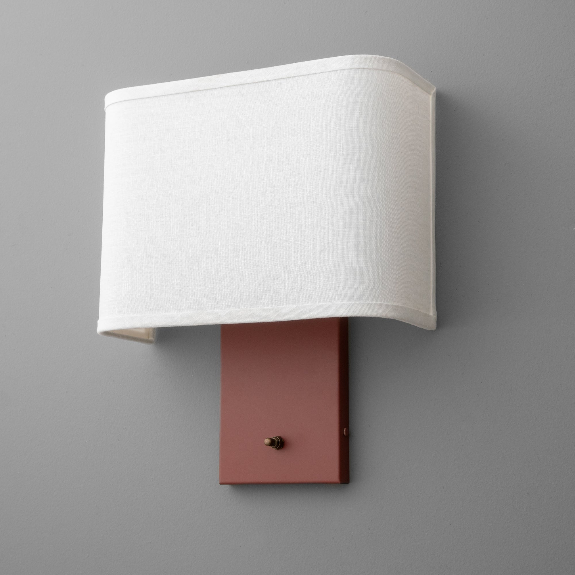 Wall sconce with a rectangular mauve base and a curved white fabric shade. - SCONCE MODEL NO. 7769