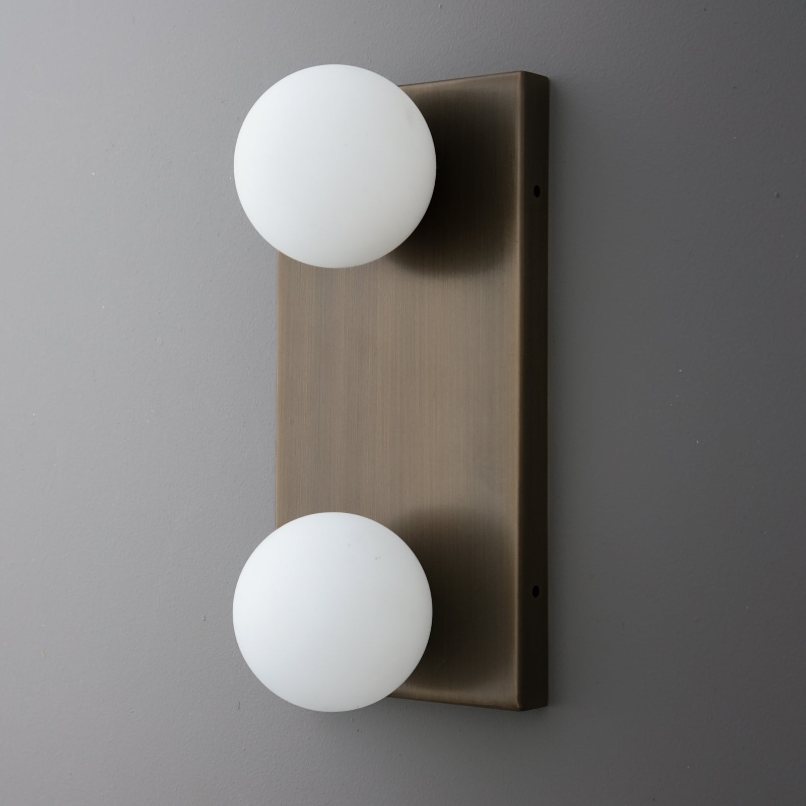 Two-bulb wall sconce with frosted white glass globes on a rectangular brushed bronze metal backplate. - SCONCE MODEL NO. 4016