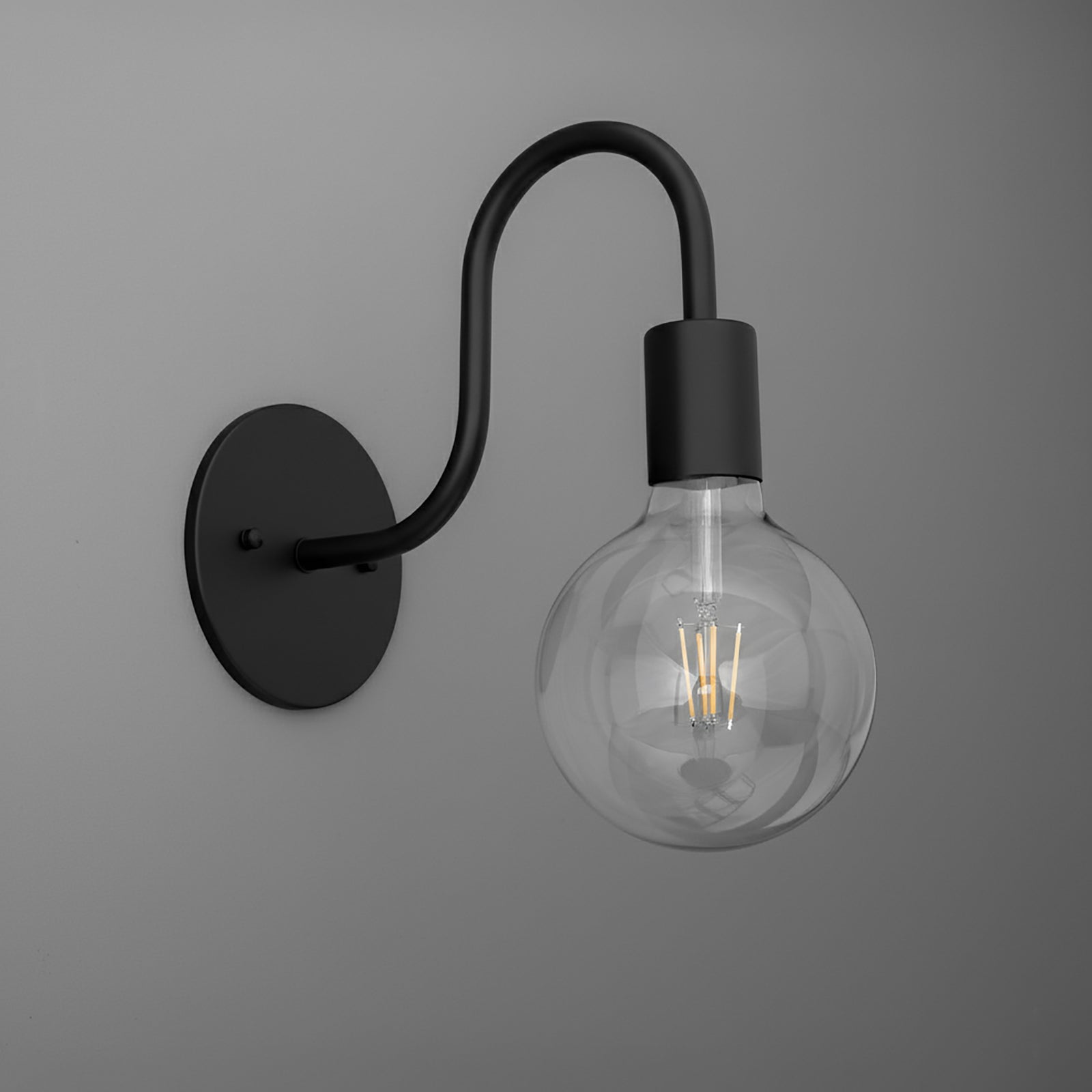 Black metal single-bulb wall sconce with curved arm and clear round filament bulb. - SCONCE MODEL NO. 4753