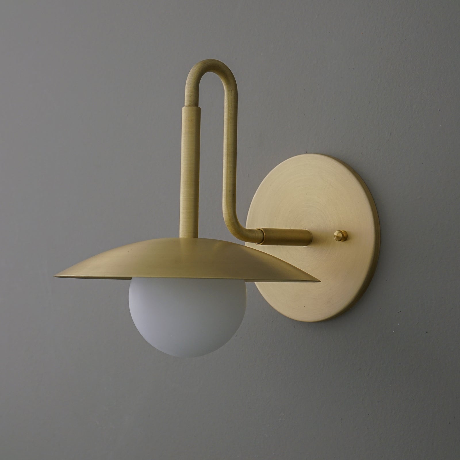 Matte gold metal wall sconce with a flat dome shade and frosted glass globe bulb. - SCONCE MODEL NO. 1013