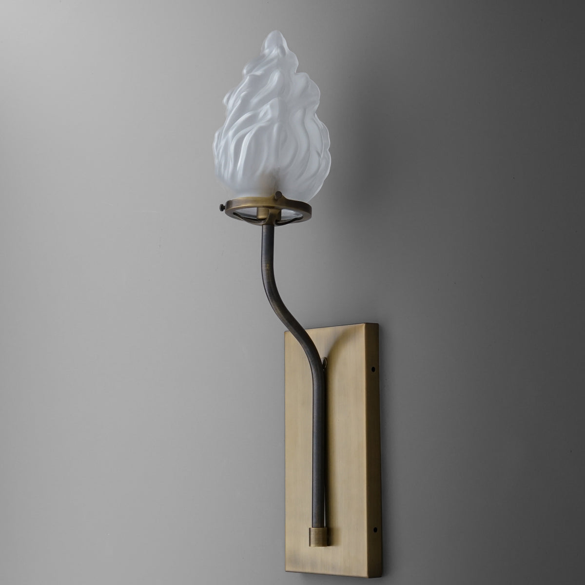 Wall sconce with brass rectangular backplate and curved black arm holding a white flame-shaped glass shade. - SCONCE MODEL NO. 7420