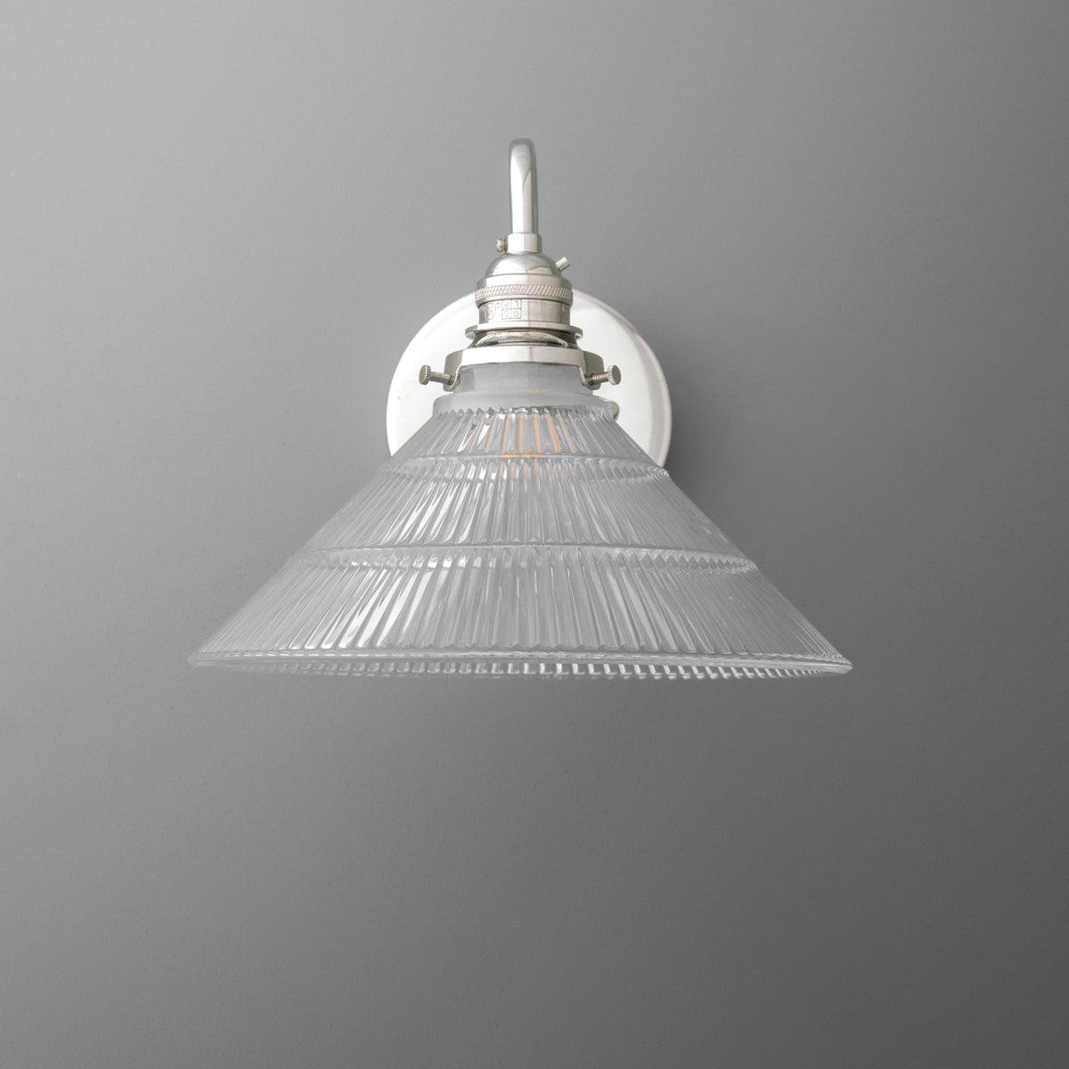 Wall-mounted single-bulb sconce with clear ribbed glass conical shade and white metal fixture. - SCONCE MODEL NO. 4703