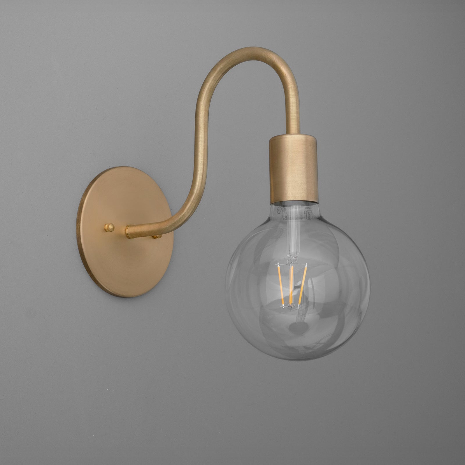 Brushed brass wall sconce with curved arm and exposed globe filament bulb. - SCONCE MODEL NO. 4753