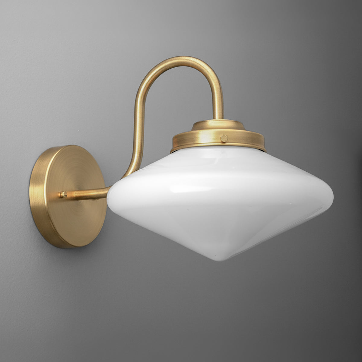 Brushed brass wall sconce with curved arm and white opaque glass shade in a rounded diamond shape. - SCONCE MODEL NO. 1021