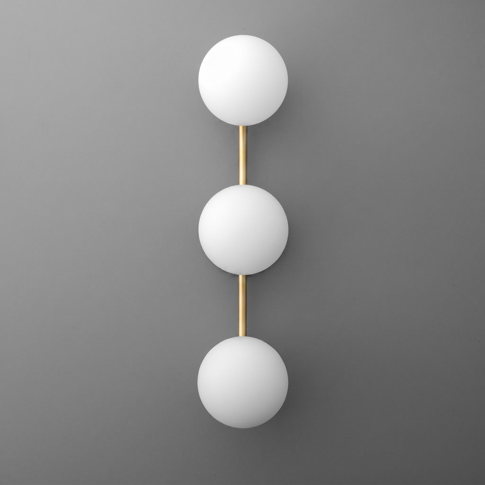 Modern wall sconce with three white glass globes aligned vertically on a gold metal frame. - SCONCE MODEL NO. 9250