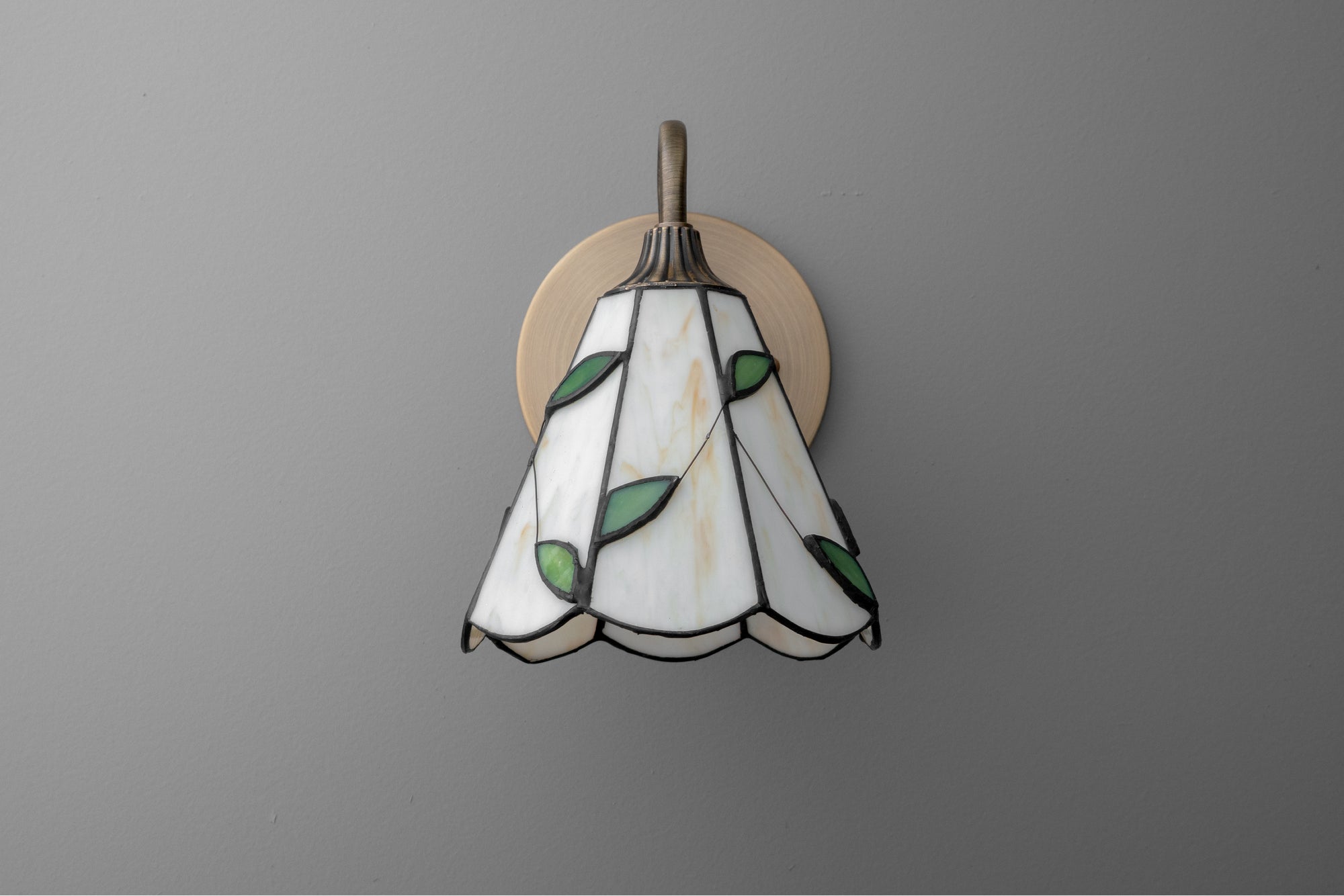 Stained glass sconce with white and green leaf design and antique brass wall mount. - SCONCE MODEL NO. 8543