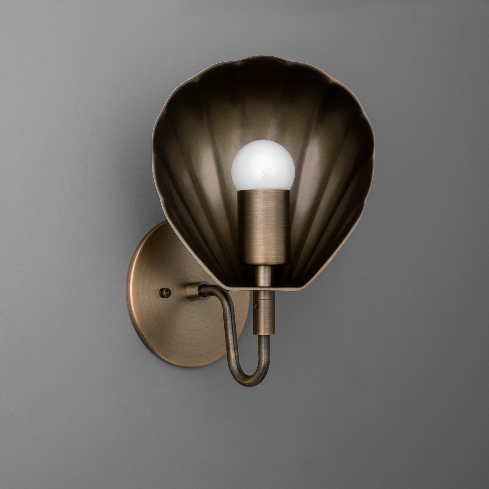 Bronze scallop shell-shaped single-bulb wall sconce with cylindrical bulb holder and round backplate. - SCONCE MODEL NO. 1086
