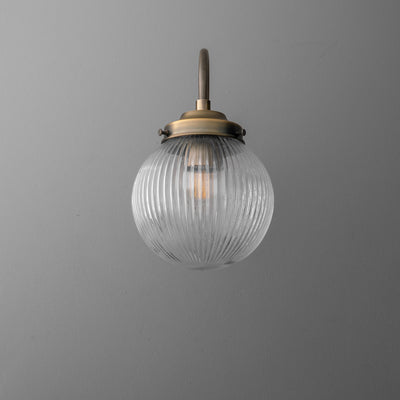Wall-mounted sconce with ribbed clear glass globe and antique brass finish fixture. - SCONCE MODEL NO. 0691