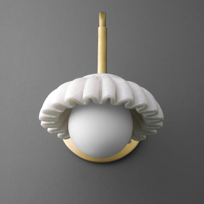 Wall sconce with a white ruffled ceramic shade and a brass mounting arm against a gray background. - SCONCE MODEL NO. 8633