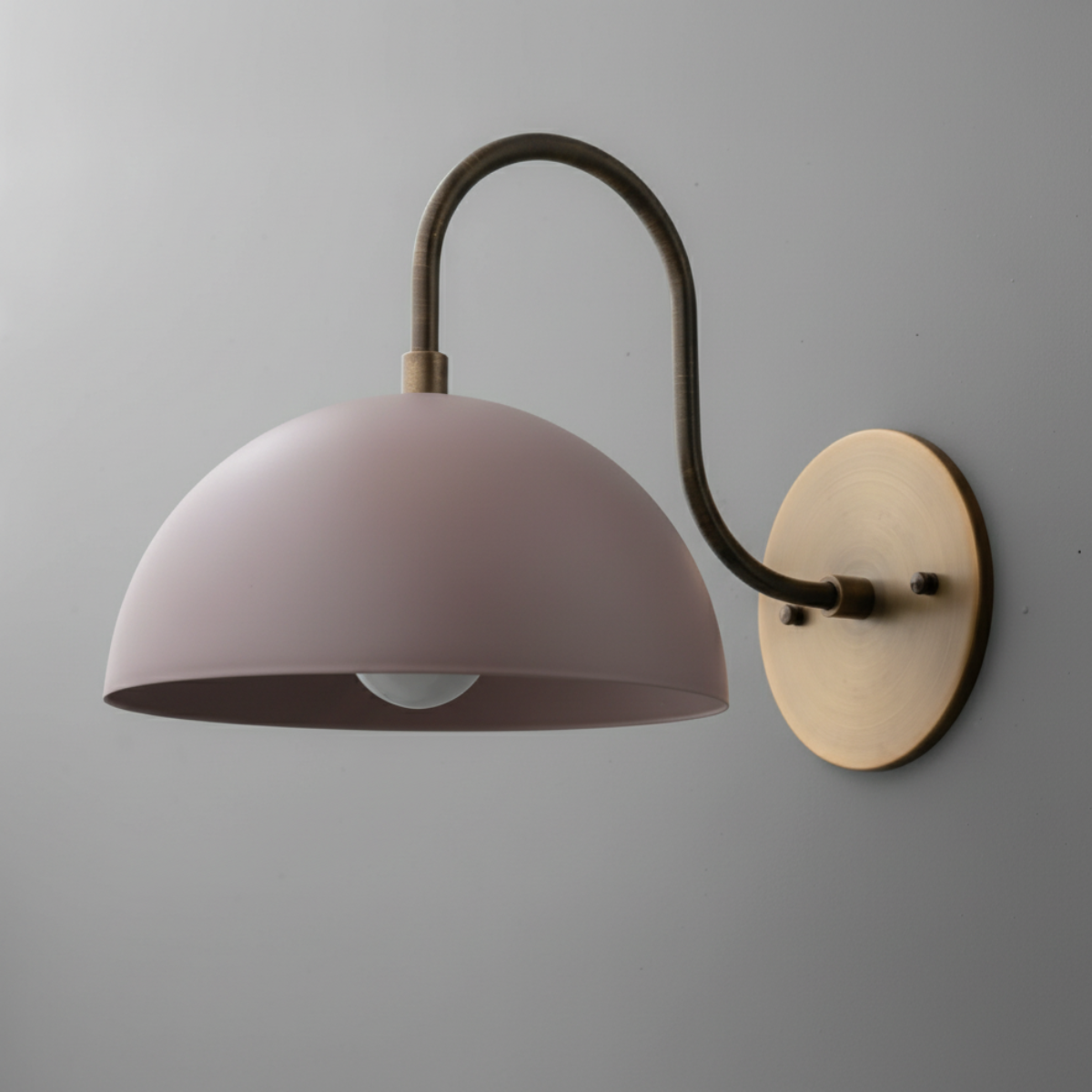 Wall sconce with curved antique brass arm and mauve dome-shaped metal shade mounted on round brass base. - SCONCE MODEL NO. 9092