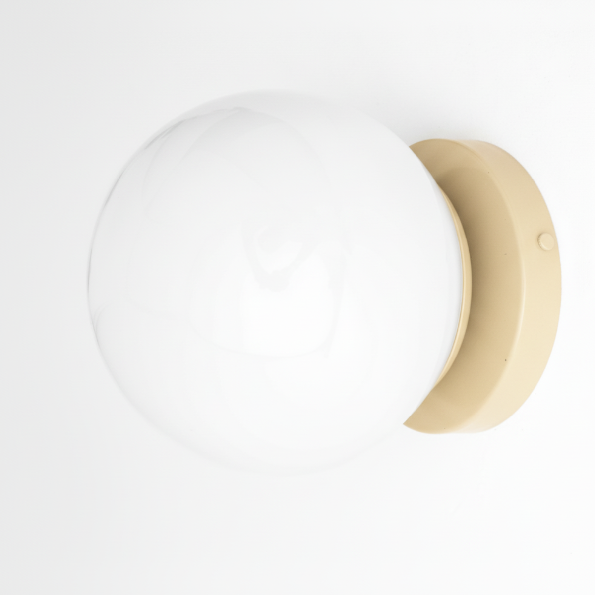 Mid-century modern wall sconce with a cream circular base and a large white glass globe shade. - SCONCE MODEL NO. 3825