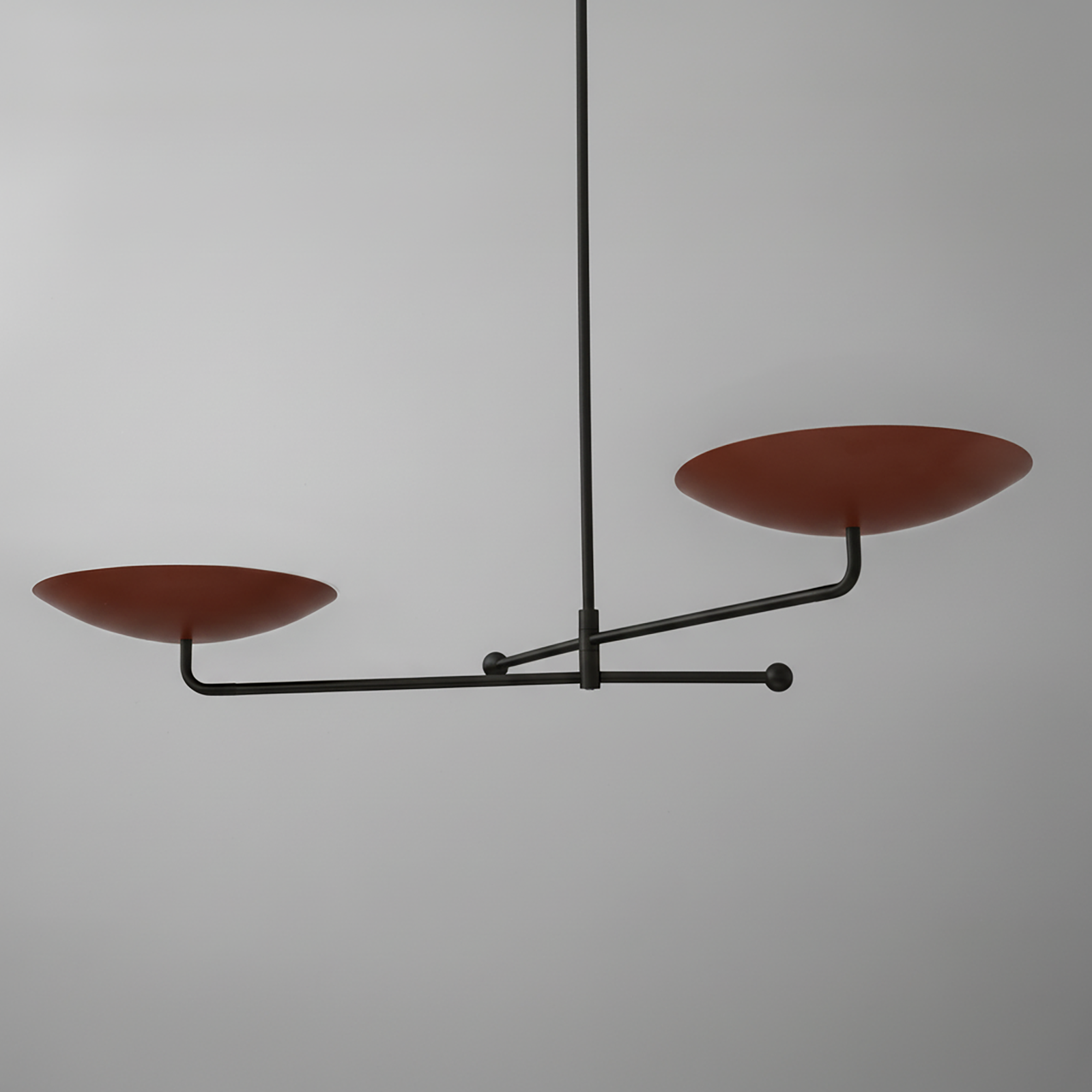 Modern chandelier with two flat, round, rust-colored metal shades on a black horizontal rod suspended by a slim vertical rod. - CHANDELIER MODEL NO. 0680