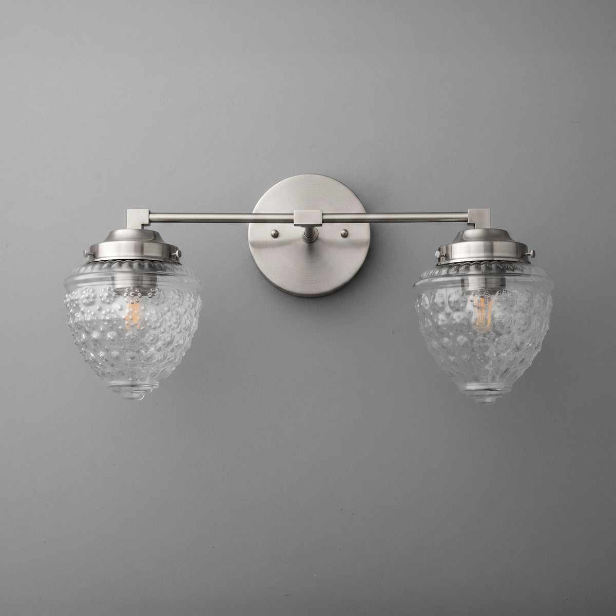 Brushed nickel two-bulb vanity light with textured glass globe shades and round wall mount. - VANITY LIGHT MODEL NO. 1155