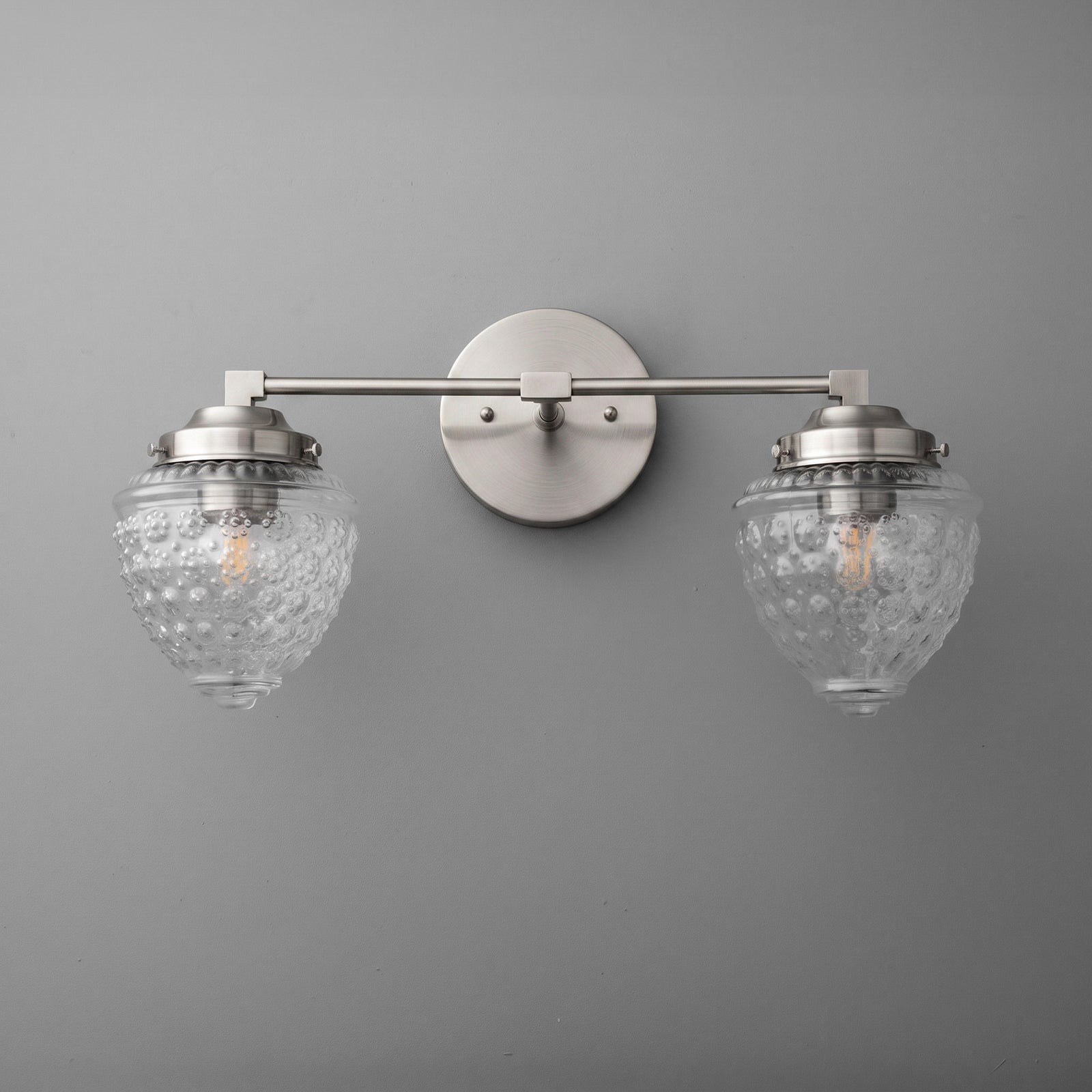 Brushed nickel two-bulb vanity light with textured glass globe shades and round wall mount. - VANITY LIGHT MODEL NO. 1155