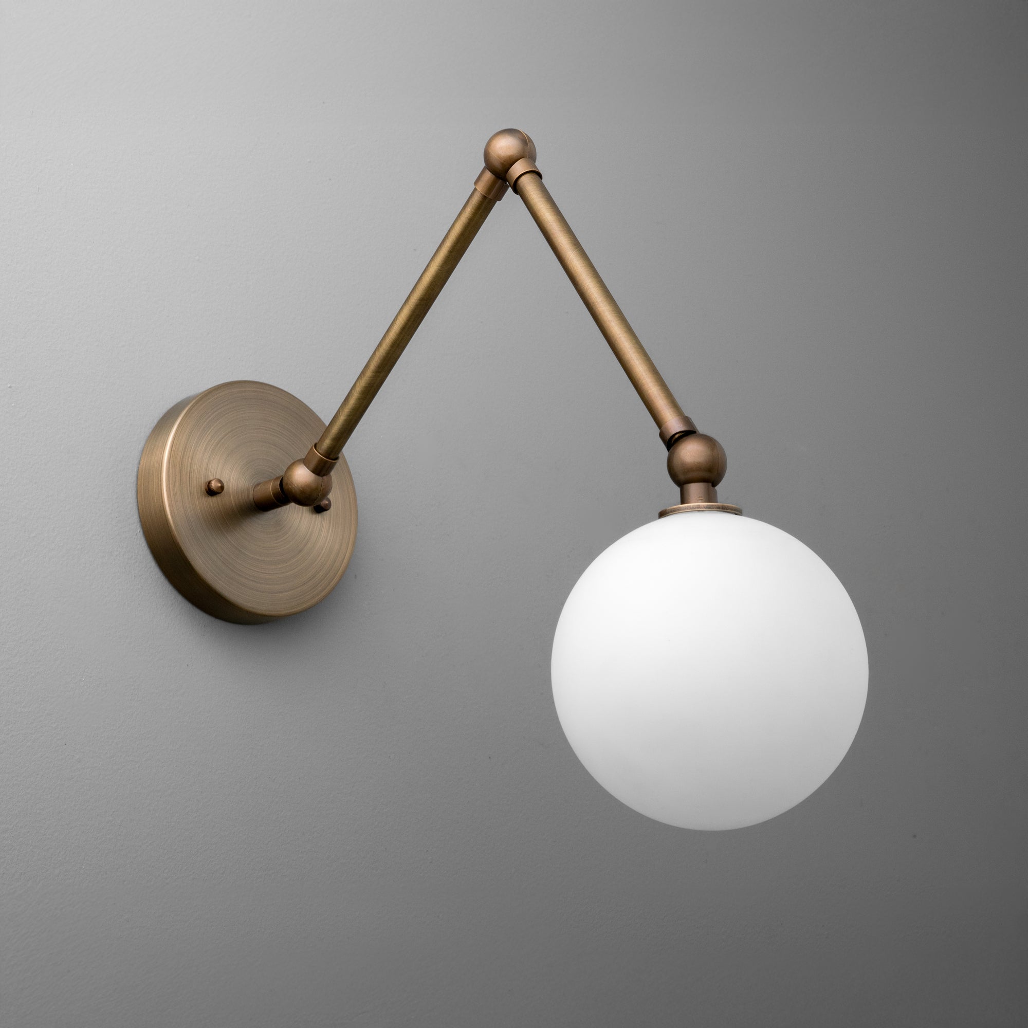 Wall sconce with antique brass finish and white frosted glass globe shade. - SCONCE MODEL NO. 5202