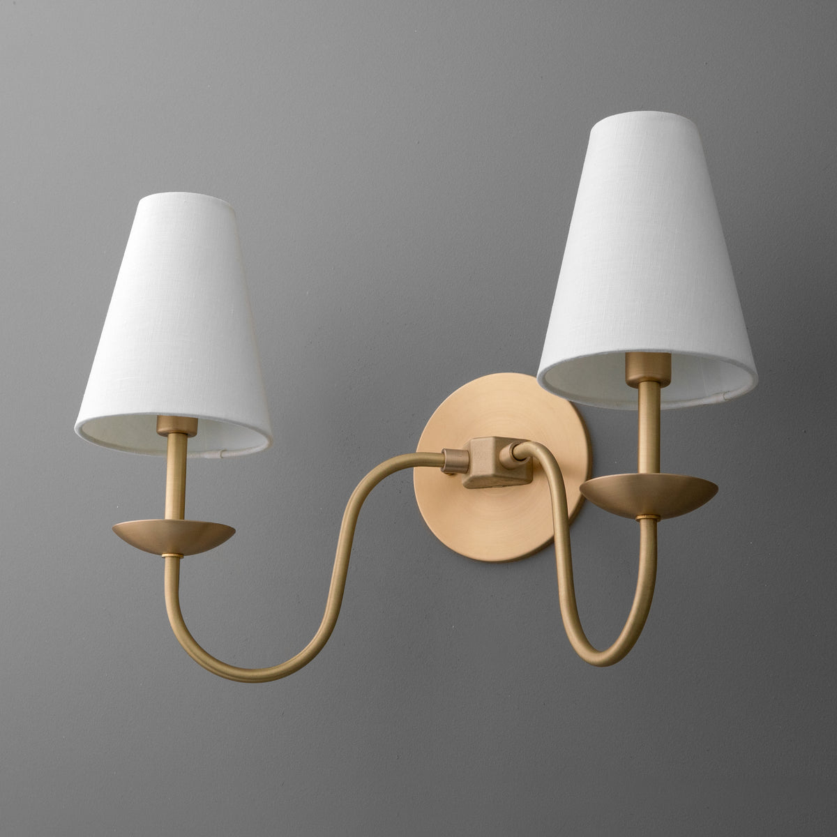 Brushed brass two-arm wall sconce with white tapered fabric shades and circular backplate. - SCONCE MODEL NO. 5846
