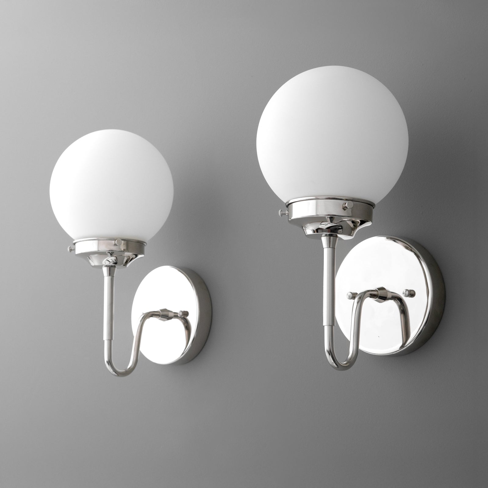 Wall-mounted sconce with a round white glass globe shade and polished chrome base and arm. - SCONCE MODEL NO. 3690