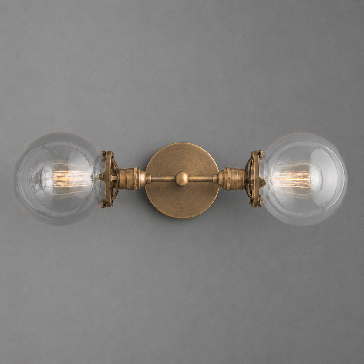 Vintage brass two-bulb vanity light with clear glass globe shades and exposed filament bulbs. - VANITY LIGHT MODEL NO. 7350