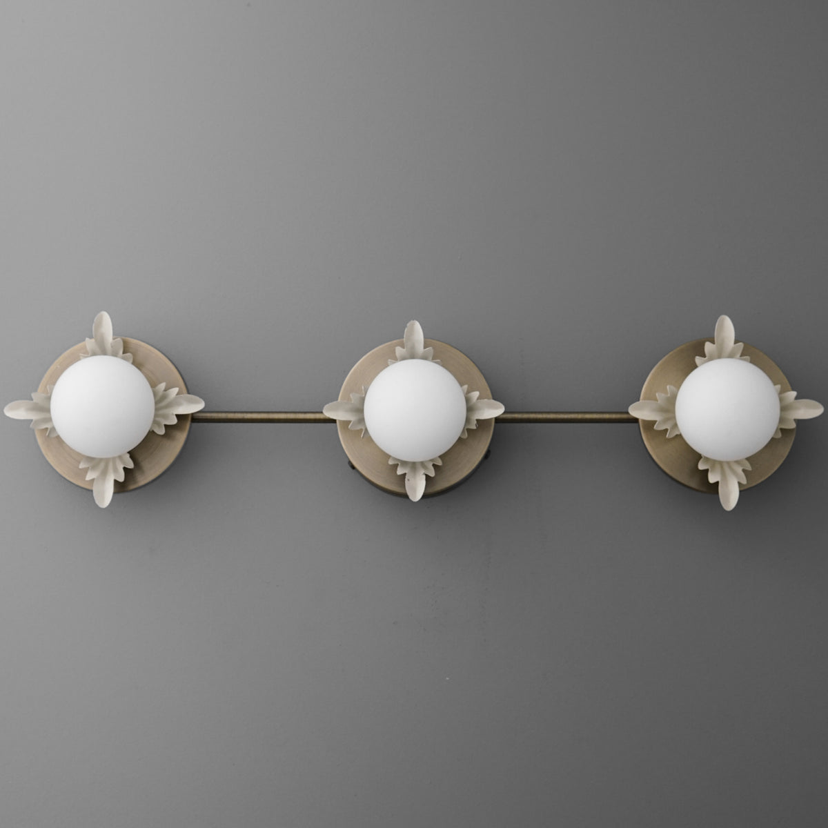 Three-bulb vanity light fixture with round white glass shades and brushed nickel finish on mounting plate and arms. - VANITY LIGHT MODEL NO. 1154