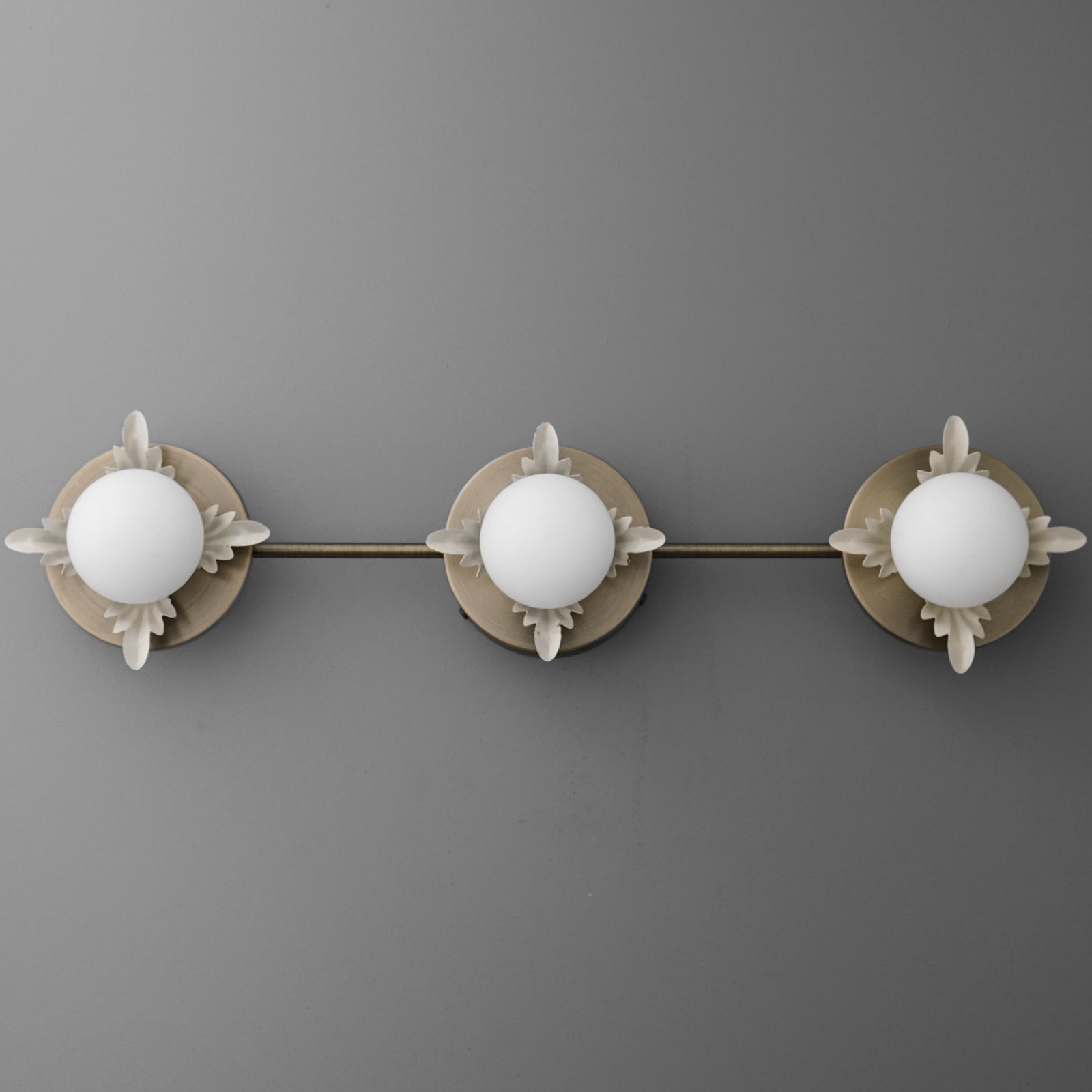 Three-bulb vanity light fixture with round white glass shades and brushed nickel finish on mounting plate and arms. - VANITY LIGHT MODEL NO. 1154