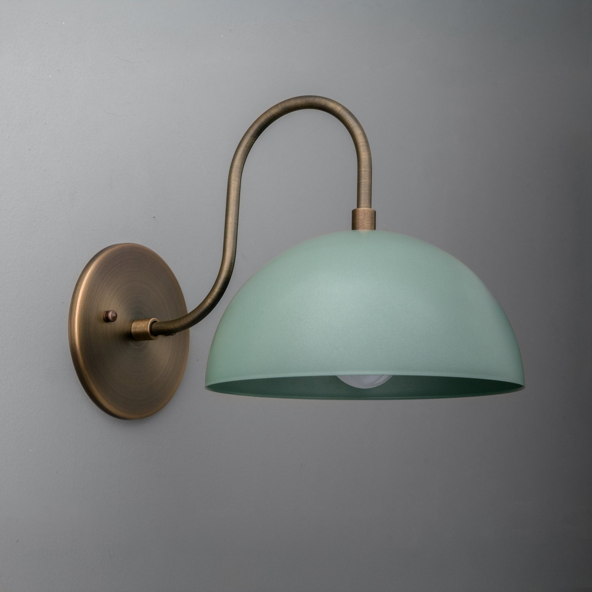 Raw brass wall sconce with curved arm and dome-shaped periwinkle blue metal shade. - SCONCE MODEL NO. 9092