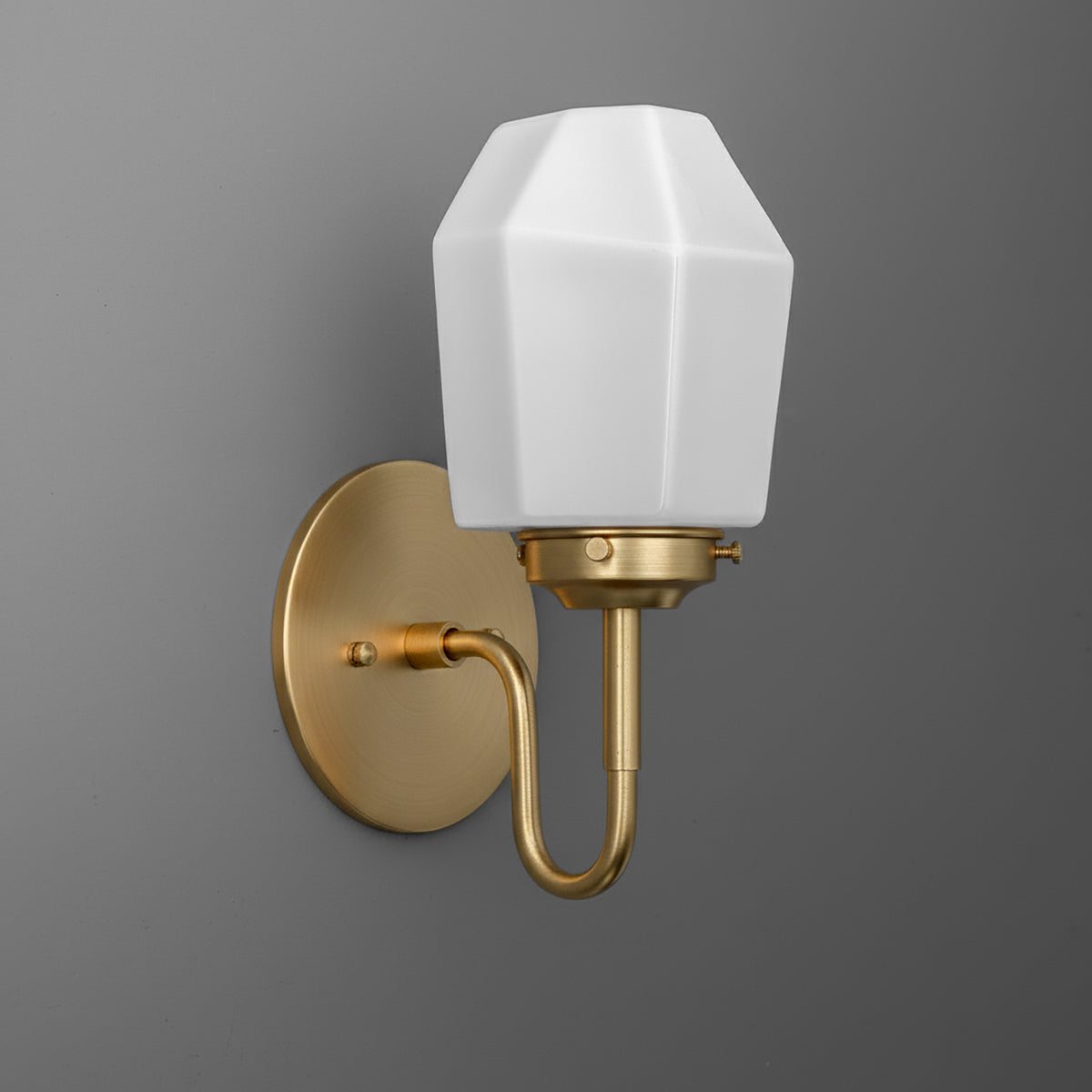 Wall sconce with brushed brass finish, curved arm, and white faceted glass shade. - SCONCE MODEL NO. 1038