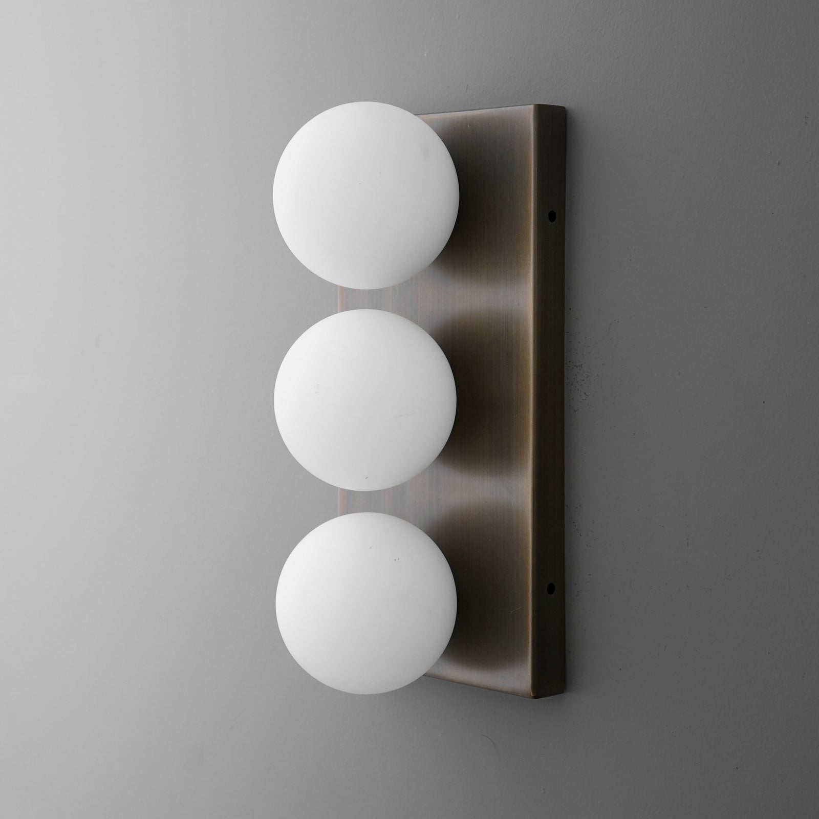 Modern wall sconce with three evenly spaced white frosted glass globes on a brushed metal rectangular base. - SCONCE MODEL NO. 2623