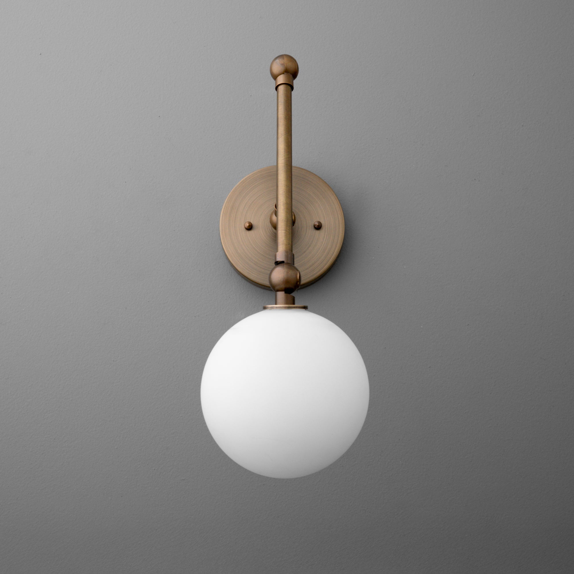 Antique brass wall sconce with round backplate and white frosted glass globe shade. - SCONCE MODEL NO. 5202