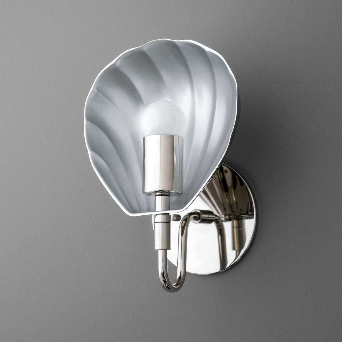 Single-bulb silver sconce with shell-shaped backplate and polished round wall mount. - SCONCE MODEL NO. 1086