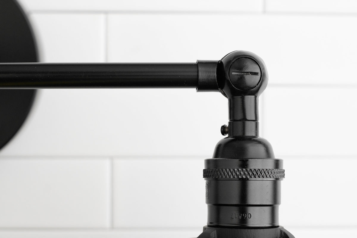 Matte black industrial vanity light arm with knurled detailing against white subway tile background. - VANITY LIGHT MODEL NO. 5348