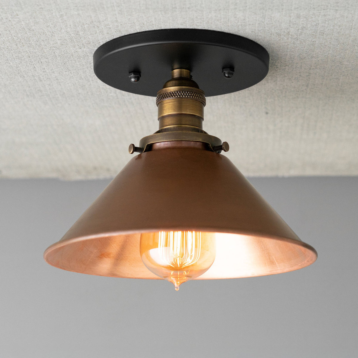 Flush ceiling light with a Black canopy and an Antique Brass socket and cone shade over an exposed filament bulb. - CEILING LIGHT MODEL NO. 6295