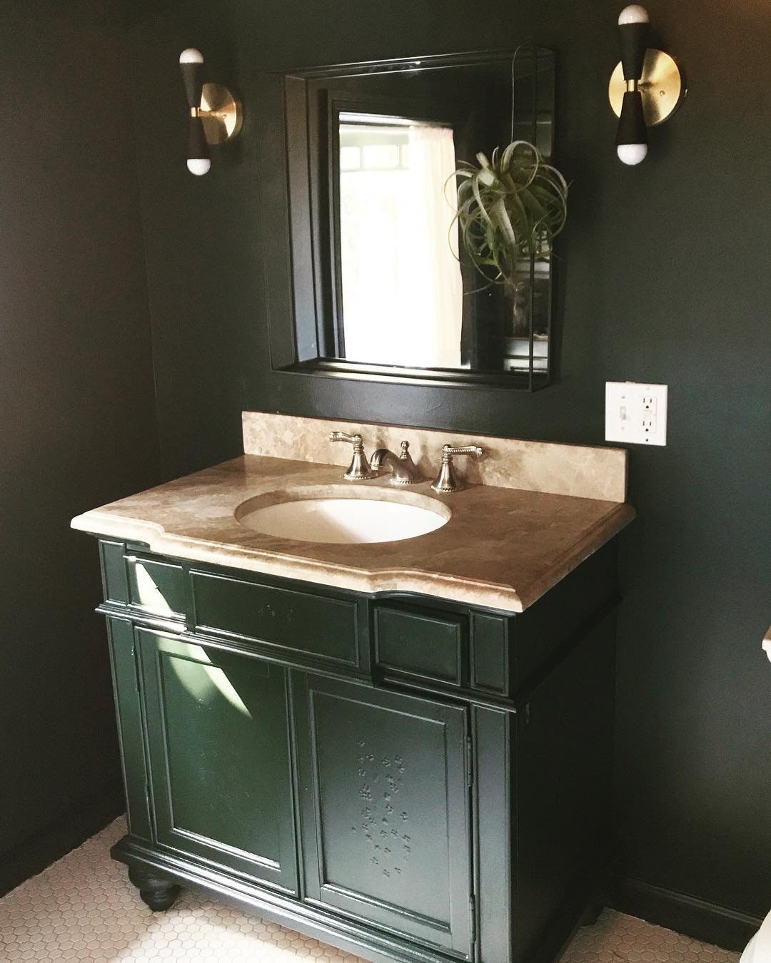 Raw brass and black metal Art Deco up/down wall sconce with exposed bulbs on dark wall above bathroom vanity. - SCONCE MODEL NO. 4717