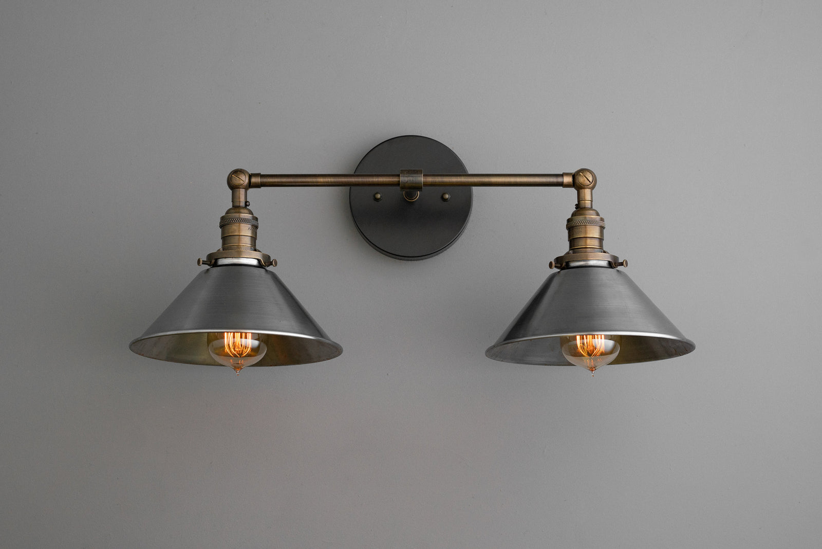 Industrial-style 2-bulb vanity light with black metal shades and antique brass finish mounting arm. - VANITY LIGHT MODEL NO. 0799