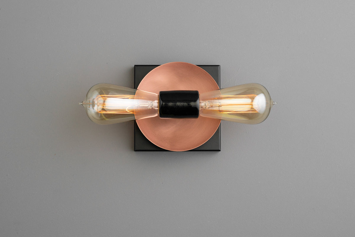 Industrial wall sconce with bare bulbs, copper circular backplate, and black square mount. - SCONCE MODEL NO. 8169