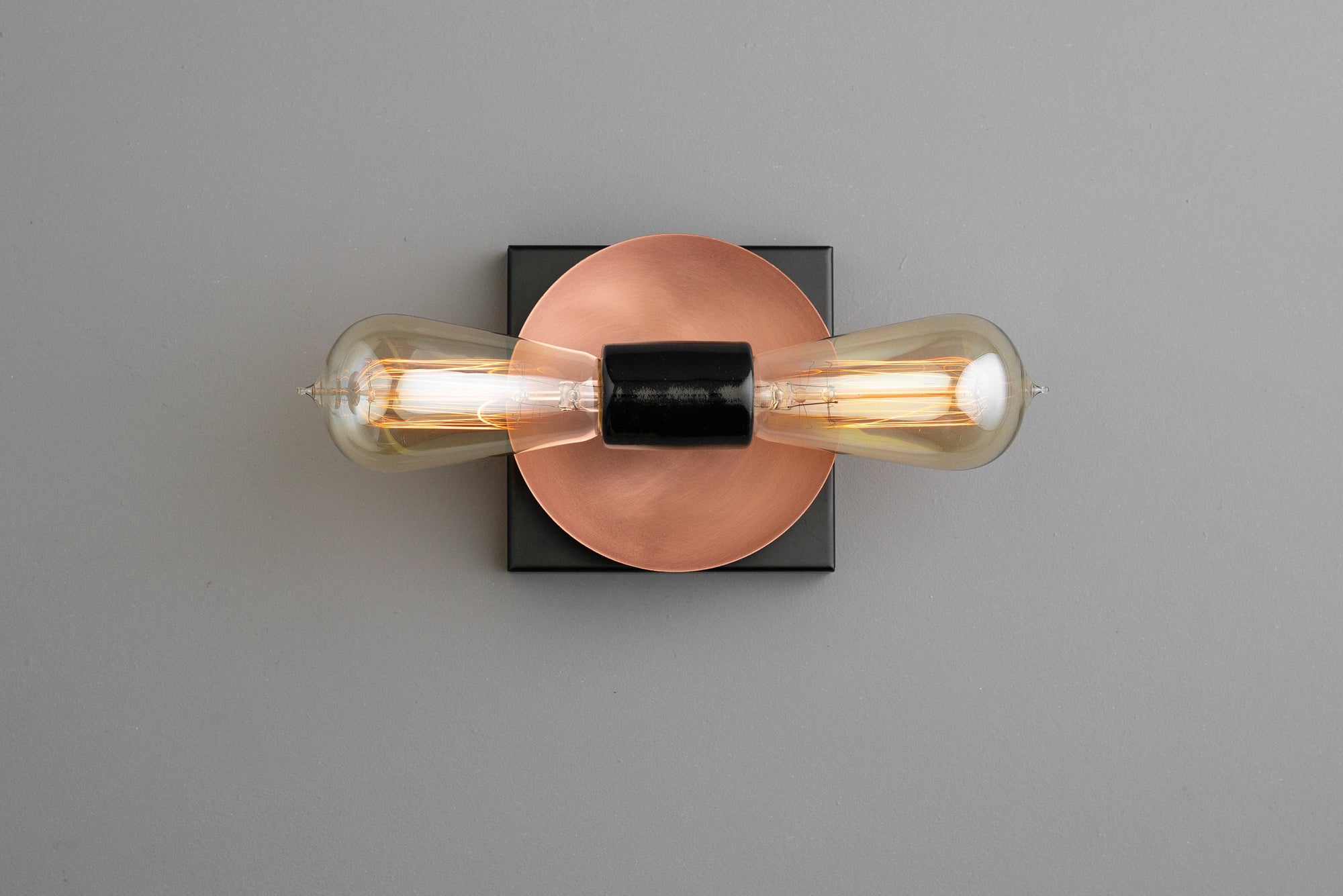 Industrial wall sconce with bare bulbs, copper circular backplate, and black square mount. - SCONCE MODEL NO. 8169