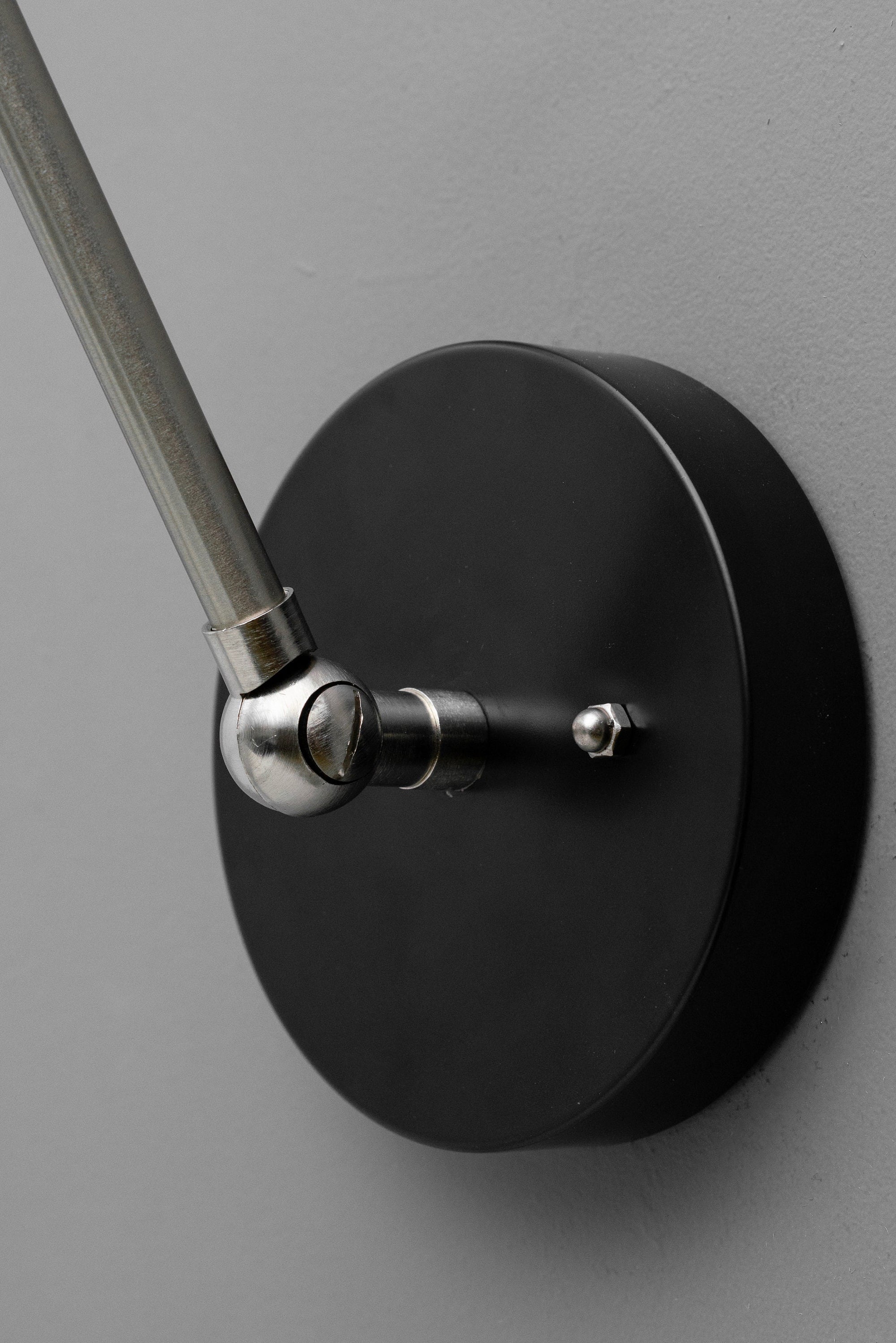 Black industrial wall sconce base with adjustable brushed nickel arm mount and round backplate. - SCONCE MODEL NO. 7164