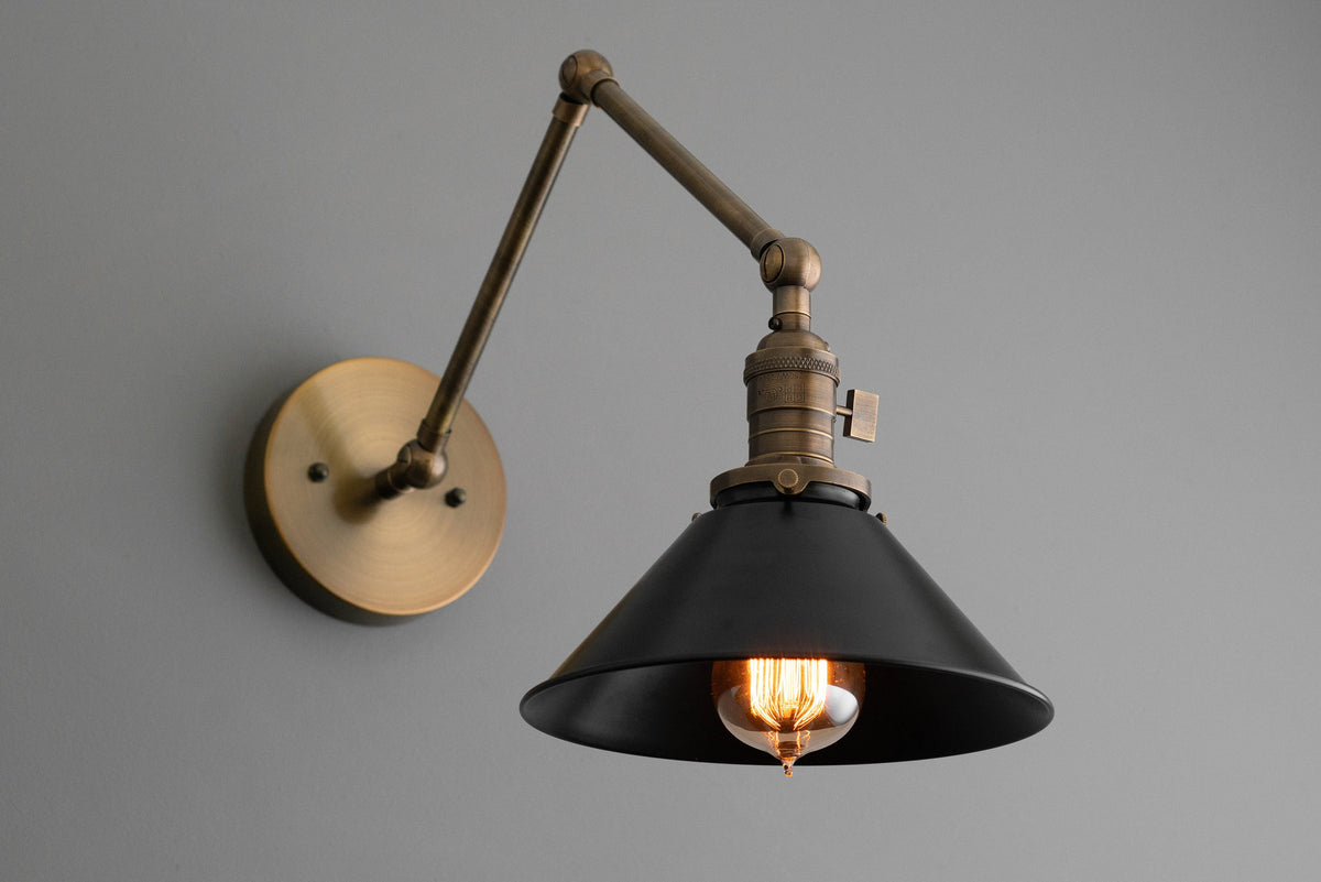 Adjustable industrial wall sconce with matte black conical shade and antique brass arm and mounting plate. - SCONCE MODEL NO. 7164