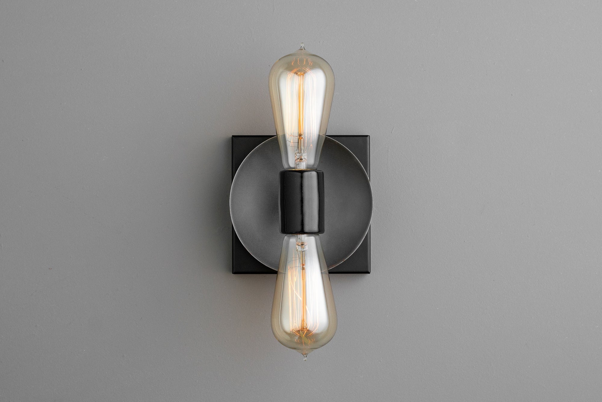 Industrial-style black metal sconce with exposed vintage-style filament bulbs in vertical arrangement. - SCONCE MODEL NO. 8169