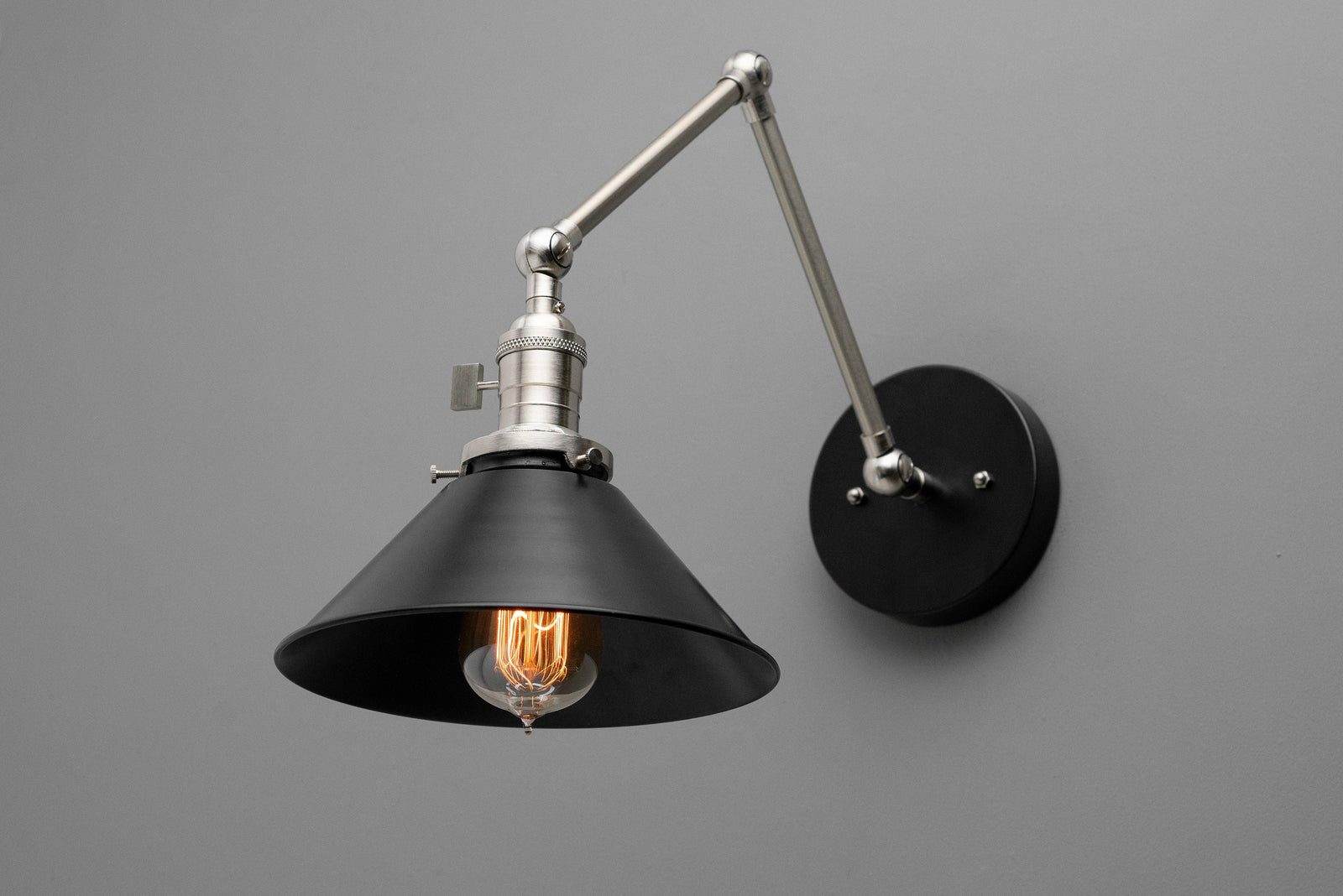 Adjustable black industrial wall sconce with metal shade and exposed vintage bulb. - SCONCE MODEL NO. 7164