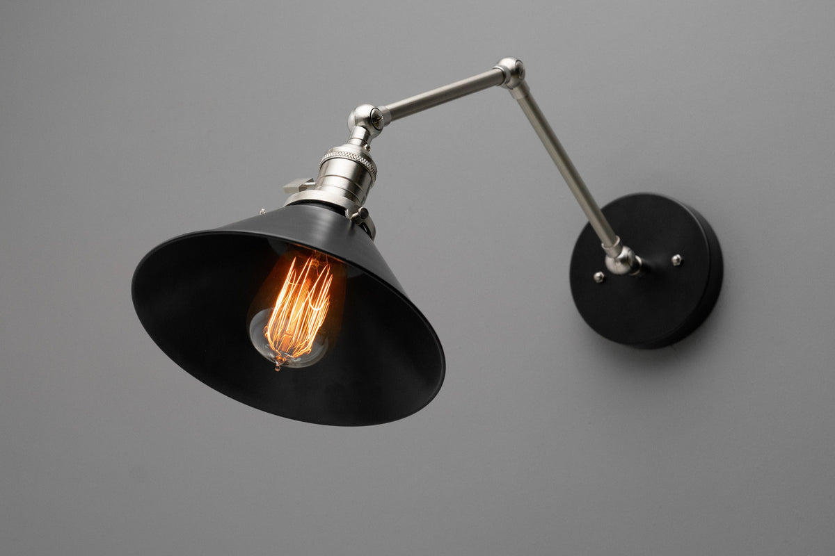 Adjustable industrial wall sconce with matte black conical shade and brushed nickel arm mounted on round black base. - SCONCE MODEL NO. 7164